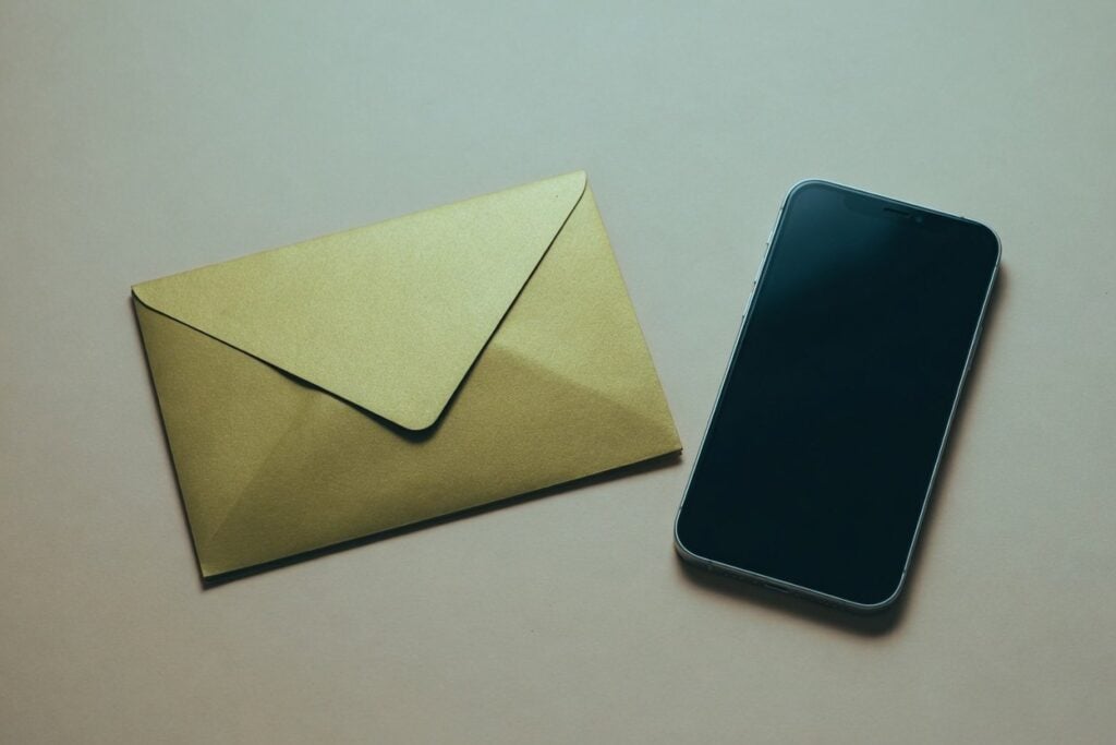 Envelope and smartphone on a desk, suggesting reverse email search identity.