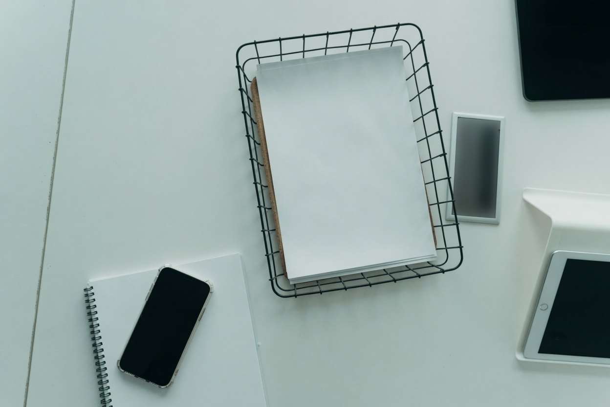 How to Check and Reduce Your Digital Footprint 2 Desk with notebook, phone, wire tray, and tablets