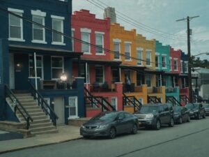 A row of colorful townhouses with cars parked in front, the starting point for a reverse directory search by address