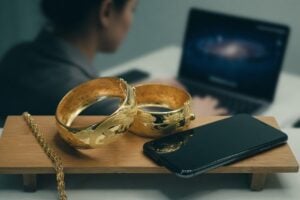 Gold rings and a smartphone on a table, illustrating hinge profile finder free methods.