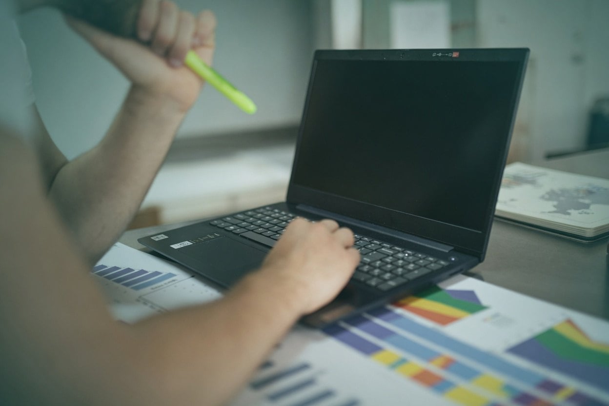 How To Use LinkedIn To Find An Address 2 A person working on a laptop with colorful graphs in front of them.