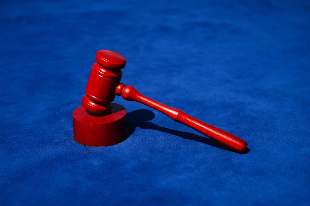 Signs of a Scammer 2 A red gavel on a blue surface