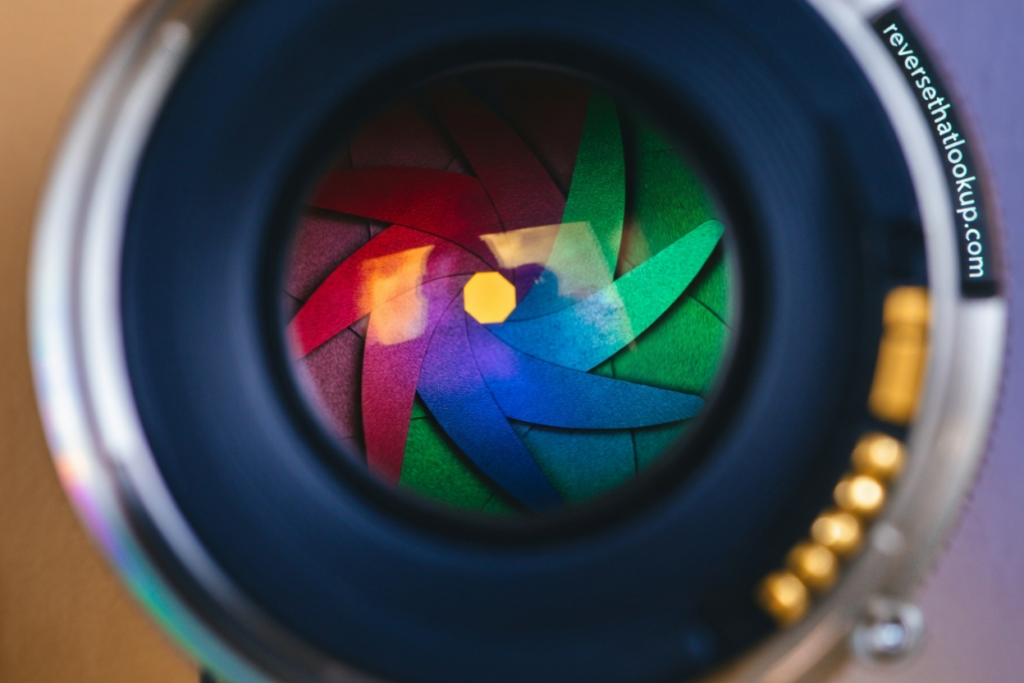 Camera lens close-up with colorful aperture blades, like a smoke alarm hidden camera.