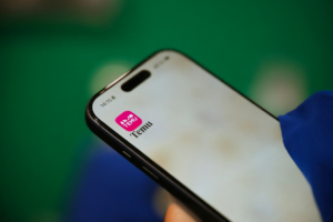 A hand holds a phone showing the Temu app, relevant to is temu safe.