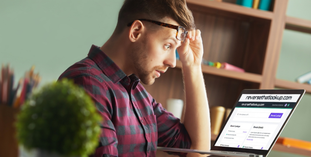 Man studies a laptop during facebook phone number search.