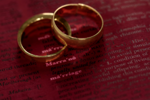 Two gold rings on a red page for how to find out if someone is married.