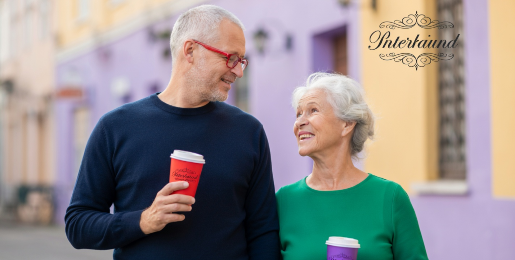 Smiling older couple holding coffee cups for dating sites for seniors.